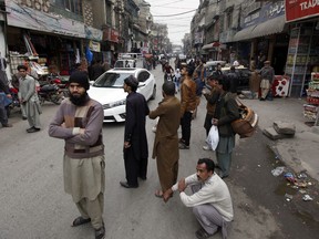 People stand outside their shops after a severe earthquake is felt in Rawalpindi, Pakistan, Wednesday, Jan. 31, 2018. A strong magnitude 6.1 earthquake rattled Pakistan and Afghanistan, including the capital cities of both countries, on Wednesday, killing a young girl and injuring five others and damaging mud-brick homes in southwestern Pakistan, officials said.
