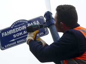 A municipal worker fixes a sign replacing 613th Street with Fahreddin Pasha Street in Ankara, Turkey, Tuesday, Jan. 9, 2018. Turkey has renamed a street housing the United Arab Emirates' embassy after an Ottoman military commander, in reaction to an Emirati minister who retweeted a post accusing President Recep Tayyip Erdogan's "forefathers" of pillaging the holy city of Medina. An adjacent street was renamed Defender of Medina (Fahreddin Pasha) Street. (AP Photo)