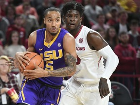 LSU's Daryl Edwards drives to the basket in front of Arkansas' Jaylen Barford during an NCAA college basketball game Wednesday, Jan. 10, 2018, in Fayetteville, Ark.