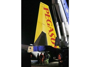 People work on a recovery operation around a Boeing 737-800 of Turkey's Pegasus Airlines in Trabzon, Turkey, Thursday, Jan. 18, 2018. The commercial airplane that skidded off the runway after landing in the city in northern Turkey dangled precariously off a muddy cliff with its nose only a few feet from the Black Sea. Some of the 168 people on board described it as a "miracle" that everyone was evacuated safely from the plane.