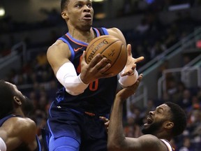 Oklahoma City Thunder guard Russell Westbrook (0) drives on Phoenix Suns guard Troy Daniels in the first half during an NBA basketball game, Sunday, Jan. 7, 2018, in Phoenix.