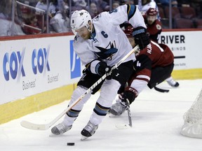 San Jose Sharks center Joe Pavelski (8) shields Arizona Coyotes defenseman Niklas Hjalmarsson from the puck in the first period during an NHL hockey game, Tuesday, Jan. 16, 2018, in Glendale, Ariz.