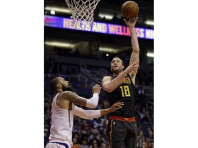 Atlanta Hawks center Miles Plumlee (18) shoots over Phoenix Suns center Tyson Chandler in the first half during an NBA basketball game, Tuesday, Jan. 2, 2018, in Phoenix.