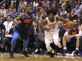 Phoenix Suns forward Josh Jackson (20) drives on Oklahoma City Thunder guard Raymond Felton in the second half during an NBA basketball game, Sunday, Jan. 7, 2018, in Phoenix. The Suns defeated the Thunder 114-100.
