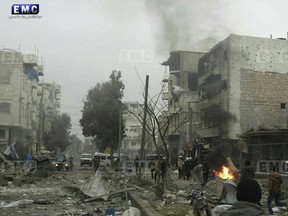 In this photo provided on Wednesday Jan. 3, 2018 by the Syrian anti-government activist group, Edlib Media Center, EMC, which has been authenticated based on its contents and other AP reporting, shows members of the Syrian civil defense known as the White Helmets, gathering at a street which was attacked by Russian airstrikes, in Maarat al-Nuaman town, southern Idlib province, Syria. Syrian government forces and allied militiamen are advancing on the largest remaining rebel-held territory in the country's north, forcing thousands of civilians to flee toward the border with Turkey amid a crushing offensive just as the cold winter weather sets in.
