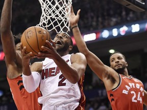 Miami Heat guard Wayne Ellington goes up for a shot past Toronto Raptors forward Norman Powell, right, and centre Lucas Nogueira in Toronto on Tuesday.