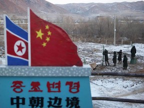 FILE - In this Dec. 8, 2012, file photo, Chinese paramilitary policemen build a fence near a concrete marker depicting the North Korean and Chinese national flags with the words "China North Korea Border" at a crossing in the Chinese border town of Tumen in eastern China's Jilin province. A U.S. Treasury official said Wednesday she has urged officials in Hong Kong and Beijing to step up measures to counter North Korean smuggling and financing, as part of Washington's fine tuning of efforts to shut down Pyongyang's nuclear program.