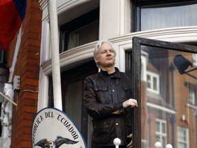 FILE- In this Friday May 19, 2017 file photo, WikiLeaks founder Julian Assange greets supporters outside the Ecuadorian embassy in London. Britain's Foreign Office said Thursday, Jan. 11, 2018 it has rejected Ecuador's request to grant diplomatic status to Assange, who has been living in the nation's embassy in London since 2012 to avoid arrest by U.K. authorities.