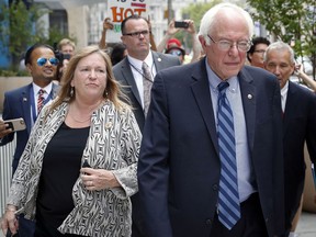 FILE - In this July 28, 2016, file photo, Sen. Bernie Sanders, I-Vt. and his wife Jane walk through downtown in Philadelphia during the final day of the Democratic National Convention. A former Burlington College trustee said she testified before a grand jury in October 2016, about a fundraising deal that was undertaken while Jane Sanders was president of the now-defunct Vermont school.