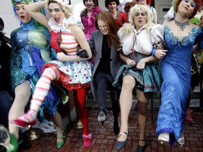 FILE - In this Jan. 27, 2011 file photo, actress Julianne Moore, center, named Harvard University's Hasty Pudding Theatricals woman of the year, dances in a kickline with male cast members dressed as women, on the steps of the New College Theatre in Cambridge, Mass. As the theater group prepares to honor its 2018 winners, critics have called for the troupe to start casting women in its burlesque musical productions and to update stage portrayals of women that some say are sexist. The group has had an all-male cast for more than 170 years.