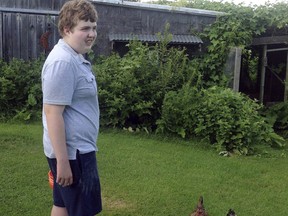 In this July 2013 photo provided by Matthew Pollack, his son Ben Pollack stands beside chickens in Sidney, Maine. Matthew and his wife Jane Quirion are fighting against a southern Maine school district to allow their non-verbal autistic son to carry an audio-recording device at school to ensure he's being treated properly.