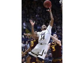 California's Don Coleman (14) lays up a shot past Arizona State's Tra Holder, left, and Mickey Mitchell (3) during the first half of an NCAA college basketball game Saturday, Jan. 20, 2018, in Berkeley, Calif.