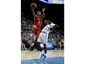 Utah guard Justin Bibbins, left, shoots over UCLA guard Aaron Holiday during the first half of an NCAA college basketball game in Los Angeles, Thursday, Jan. 11, 2018.