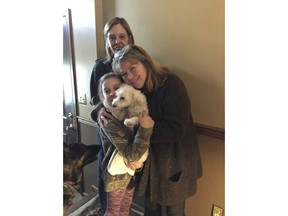 In this photo provided by Jessica Hartman, Monica Newhard, right, and her granddaughter, Helen Welch, hold their pet bichon frise, Zoey, as the dog's rescuer, Christina Hartman, stands behind them, Wednesday, Jan. 3, 2018, in Palmerton, Pa. Newhard's brother says an eagle snatched Zoey from the yard.