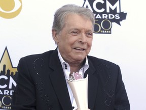 FILE - In this April 19, 2015 file photo, Mickey Gilley poses with the triple crown award on the red carpet at the 50th annual Academy of Country Music Awards at AT&T Stadium in Arlington, Texas. Country music artist Gilley and his son were injured in a car accident in Texas, but both are recovering after minor injuries. A statement from Gilley's publicist on Thursday, Jan. 4, 2018, said the two were injured Wednesday when their car rolled over.