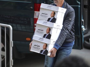 FILE - In this undated file image released Wednesday, Jan. 24, 2018 on the official Facebook account of Egyptian President Abdel-Fattah el-Sissi, shows workers carrying boxes that bear the president's image and the phrase "long live Egypt!" in Cairo Egypt. With one challenger after another leaving presidential race, Egypt's vote is starting to resemble the past. (Egyptian President's Facebook page via AP, File)