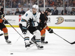 San Jose Sharks' Joe Pavelski, left, moves the puck away from Anaheim Ducks' Ryan Kesler during the second period of an NHL hockey game Sunday, Jan. 21, 2018, in Anaheim, Calif.