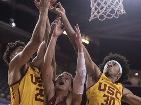 Washington State guard Malachi Flynn, center, vies for a rebound against Southern California forward Bennie Boatwright, left, and guard Elijah Stewart during the second half of an NCAA college basketball game Sunday, Dec. 31, 2017, in Los Angeles.