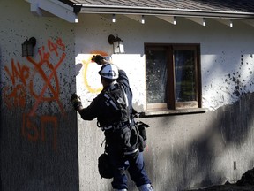 A member of a search and rescue crew marks a home as searched Saturday, Jan. 13, 2018, in Montecito, Calif.