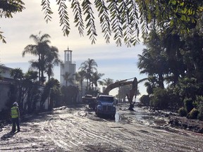 This photo provided by the Santa Barbara County Fire Department shows the cleanup of mud and debris in front of the Coral Casino and Biltmore Hotel along Channel Drive in Montecito, Calif., Wednesday, Jan. 10, 2018. Anxious family members awaited word on loved ones Wednesday as rescue crews searched grimy debris and ruins for more than a dozen people missing after mudslides in Southern California Tuesday destroyed houses, swept cars to the beach and left more than a dozen victims dead.