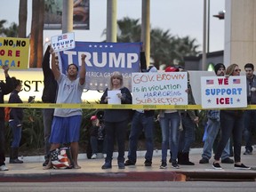 Opponents of demonstrators urging the Democratic Party to protect the Deferred Action for Childhood Arrivals Act (DACA) stand outside the office of California Democratic Sen. Dianne Feinstein in Los Angeles Wednesday, Jan. 3, 2018. California has the largest number of people who are affected by the law, also known as the Dream Act.