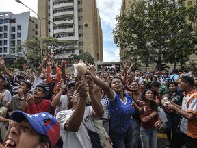 Catholic faithful ask for food during an annual procession in which the faithful carry a statue of the Divina Pastora (Divine Shepherdess) — patron saint of Barquisimeto, Venezuela, on Jan. 14, 2018.