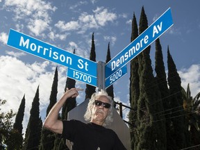 John Densmore shows the new street sign during The second annual "Day Of The Doors" event in Encino, Calif., on Thursday, Jan. 4, 2018. Los Angeles City Council member Paul Koretz unveils an intersecting street signs for Morrison Street and Densmore Avenue in Encino, in honor of founding band members Jim Morrison and John Densmore.