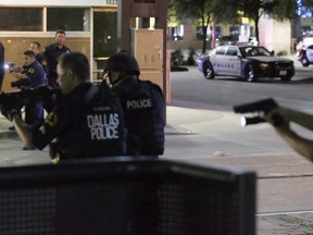 FILE - In this July 7, 2016, file photo, Dallas police move to detain a driver after several police officers were shot in downtown Dallas when a sniper opened fire at a Black Lives Matter protest. A grand jury on Wednesday, Jan. 31, 2018, declined to bring charges against Dallas police officers responsible for the death of the sniper.