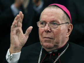 FILE - In this Sept. 21, 2011 file photo, Archbishop Daniel M. Buechlein quiets the applause as he is introduced to announce his retirement in Indianapolis. Archbishop Buechlein, the retired leader of the Indianapolis Catholic Archdiocese, has died at age 79. The archdiocese says Buechlein died early Thursday, Jan. 25, 2018, at southern Indiana's St. Meinrad Archabbey, where he had been living since his retirement in 2011 after a stroke left him too weak to stand on his own.