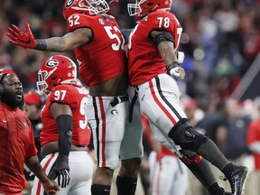 Georgia's Trenton Thompson and Tyler Clark (52) celebrate after forcing Alabama to punt during the first half of the NCAA college football playoff championship game Monday, Jan. 8, 2018, in Atlanta.