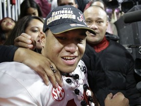 Alabama's Tua Tagovailoa celebrates with his parents Galu and Diane after overtime of the NCAA college football playoff championship game against Georgia Monday, Jan. 8, 2018, in Atlanta. Alabama won 26-23.