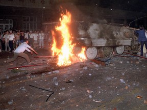 In this early June 4, 1989 file photo, a student protester puts barricades in the path of an already burning armoured personnel carrier that rammed through student lines during an army attack on anti-government demonstrators in Beijing's Tiananmen Square.
