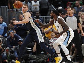 Denver Nuggets center Nikola Jokic, left, of Serbia, pulls in the ball as Memphis Grizzlies forward JaMychal Green defends in the first half of an NBA basketball game Friday, Jan. 12, 2018, in Denver.
