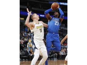 Dallas Mavericks guard Wesley Matthews, right, goes up for a basket over Denver Nuggets center Nikola Jokic, of Serbia, in the first half of an NBA basketball game Tuesday, Jan. 16, 2018, in Denver.