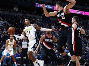 Denver Nuggets guard Gary Harris pulls in the ball as Portland Trail Blazers center Zach Collins (33) defends in the first half of an NBA basketball game Monday, Jan. 22, 2018, in Denver.