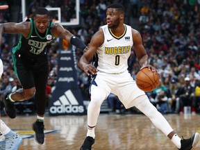 Boston Celtics guard Terry Rozier, left, fights past a pick to defend as Denver Nuggets guard Emmanuel Mudiay (0) drives to the basket in the first half of an NBA basketball game Monday, Jan. 29, 2018, in Denver.