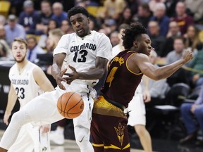 Colorado guard Namon Wright, left, struggles to pull in a rebound as he collides with Arizona State forward Kimani Lawrence during the first half of an NCAA college basketball game Thursday, Jan. 4, 2018, in Boulder, Colo.