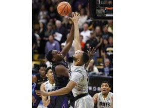 Colorado forward Dallas Walton, right, reaches up to block a shot by Washington forward Noah Dickerson during the first half of an NCAA college basketball game Saturday, Jan. 20, 2018.