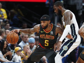 Atlanta Hawks guard Malcolm Delaney, left, works the ball inside as Denver Nuggets guard Will Barton defends in the first half of an NBA basketball game Wednesday, Jan. 10, 2018 in Denver.