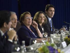 Prime Minister Justin Trudeau, right, sits beside Minister of International Trade Chrystia Freehand as they take part in a Trans-Pacific Partnership meeting on the side-lines of the APEC Summit in Manila, Philippines on Wednesday, November 18, 2015. Canada and the remaining members of the Trans-Pacific Partnership have agreed to a revised trade agreement, according to several international media reports early Tuesday.