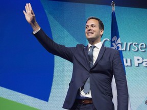 Parti Quebecois leadership candidate Alexandre Cloutier waves to supporters before hearing the leadership results at the Parti Quebecois leadership race results evening on Friday, October 7, 2016 in Levis, Quebec. Cloutier, 40, said this morning he will see out his mandate but not be a candidate for the Oct. 1 election.