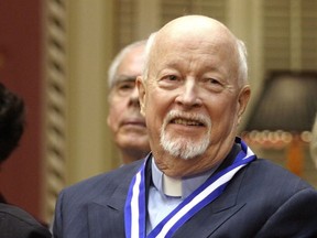 Father Emmett Johns, known as Pops in Montreal, smiles at the end of a ceremony where he was decorated with the Ordre National du Quebec as a Grand Officer, Tuesday, Oct. 28, 2003. at the Quebec Legislature.