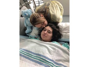 The sister of a young Quebec woman who had her limbs amputated after being electrocuted when her car struck an electrical pole in western Quebec has set up a fundraising campaign. Samantha Mongeon, left, kisses her sister Sabryna in this undated handout photo.