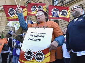 Public servants protest over problems with the Phoenix pay system outside the Office of the Prime Minister and Privy Council in Ottawa on Thursday, Oct. 12, 2017. The federal government says several hundred civil servants had their medical or dental benefits temporarily cut off as a result of ongoing issues surrounding the problem-plagued Phoenix pay system.