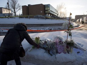 A woman places flowers near a mosque where a Sunday night shooting left six people dead, Monday, January 30, 2017 in Quebec City. The first anniversary of the tragic Quebec City mosque shooting will be commemorated by a series of events over four days.