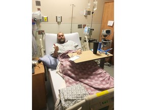Conservative MP Tedd Doherty gives a thumbs up from his hospital bed in this recent handout photo. A British Columbia Conservative member of Parliament says a hazy memory of his stricken wife's face as a medical crisis nearly killed him 10 days ago has motivated him to send a heartfelt message to his colleagues, constituents and all Canadians.