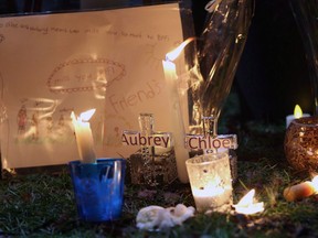 Pictures and notes in from friends and classmates make up a memorial in support and memory of Aubrey Berry, 4, and her sister Chloe, 6, during a vigil held at Willows Beach in Oak Bay, B.C., on Saturday, December 30, 2017. The father of two girls who were found dead in a Victoria-area home on Christmas Day has been charged with two counts of second-degree murder.