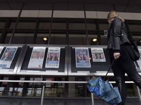 A woman views the front pages of newspapers on display outside the Newseum in Washington on November 9, 2016. Newsprint is the latest Canadian product to be hit with preliminary countervailing duties from the United States. The U.S. Department of Commerce slapped an overall tariff of 6.53 per cent on about 25 Canadian plants, mostly in Quebec and Ontario, following an investigation that began in August 2017. Canada is the largest exporter of newsprint in the world, with a market dominated by Resolute Forest Products, Kruger and Catalyst Paper Corp. of British Columbia.
