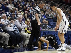 Central Florida's Aliyah Gregory kneels over after colliding with Official Bryan Enterline, left, as Connecticut's Kia Nurse, right, looks on, during the first half an NCAA college basketball game, Tuesday, Jan. 9, 2018, in Storrs, Conn.