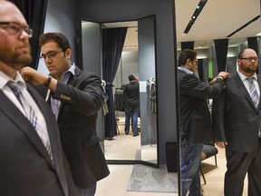 Kiavash Asghari, centre, measures customer Bobby Bartlett for a new suit at Indochino in McLean, Va. MUST CREDIT: Washington Post photo by Ricky Carioti